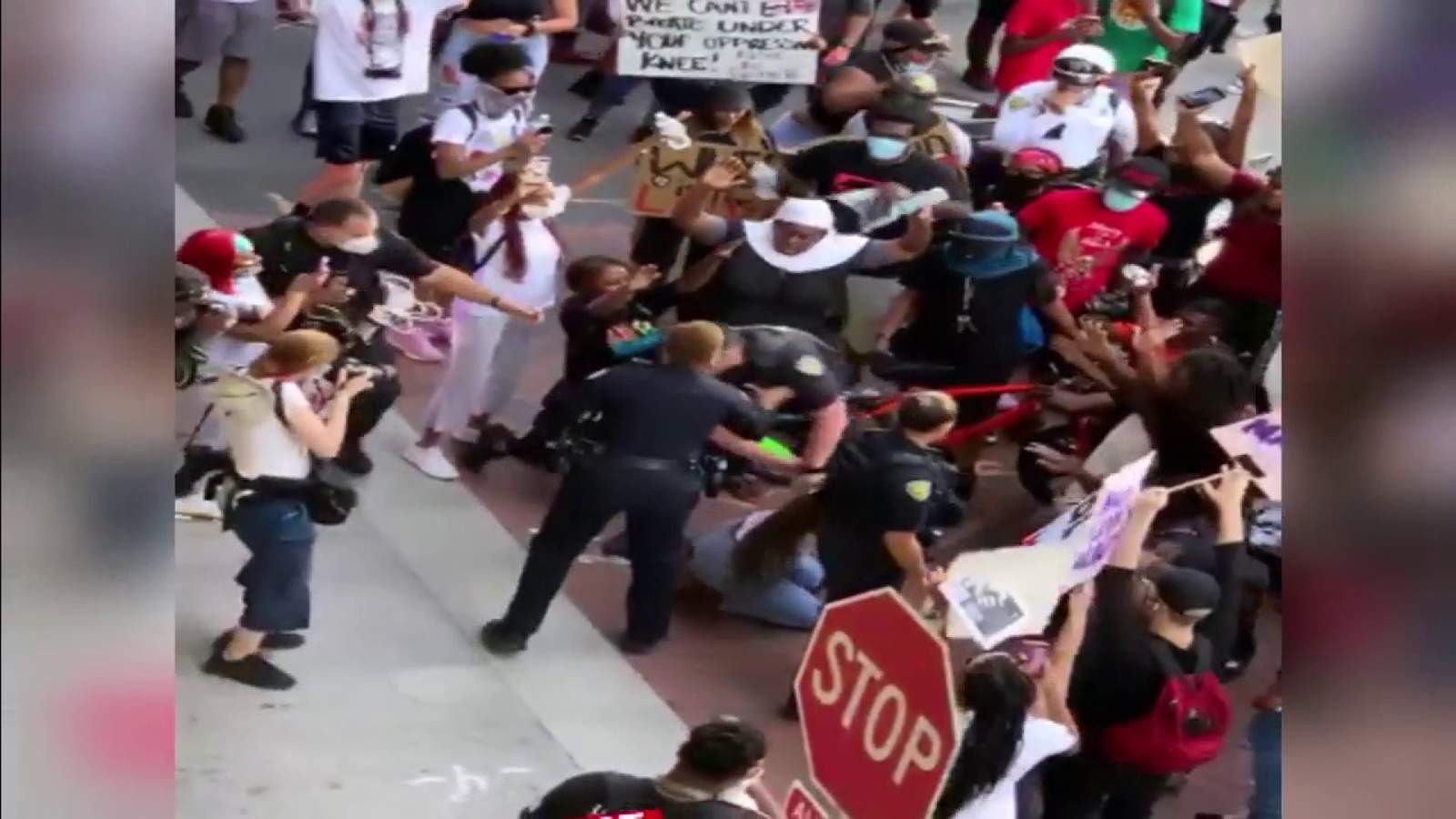 Florida police officer suspended for pushing kneeling woman during protests