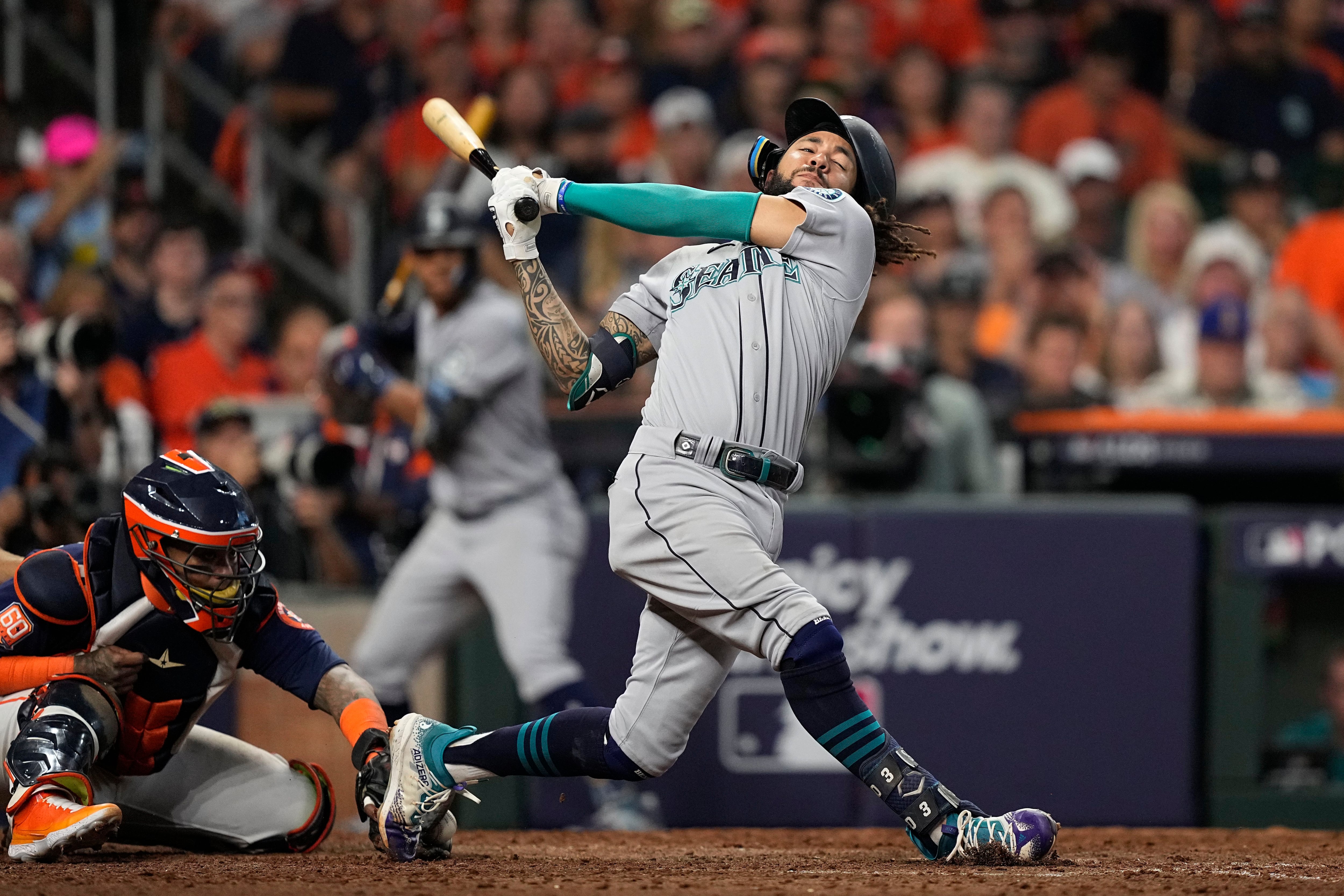 Seattle Mariners' Cal Raleigh reacts after hitting a walk-off single to win  the game 1-0 over the New York Yankees as teammate Julio Rodriguez (44)  runs towards him in a baseball game